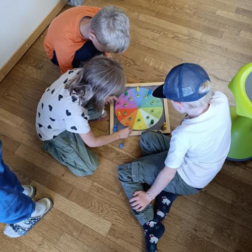 Drei Kinder spielen ein Einmaleins-Spiel