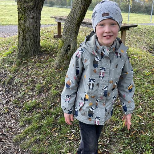 ein Junge mit grauer Mütze und Jacke