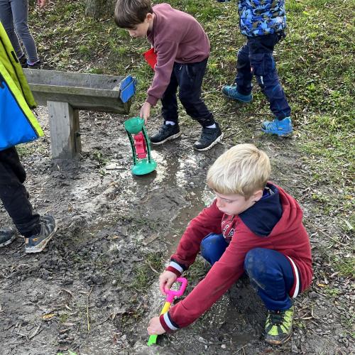 2 Buben beim Arbeiten mit Wasser und Erde.