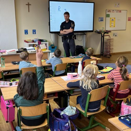 Polizist steht vor der Klasse