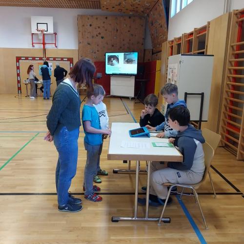Kinder und Erwachsene informieren sich an einem Stand