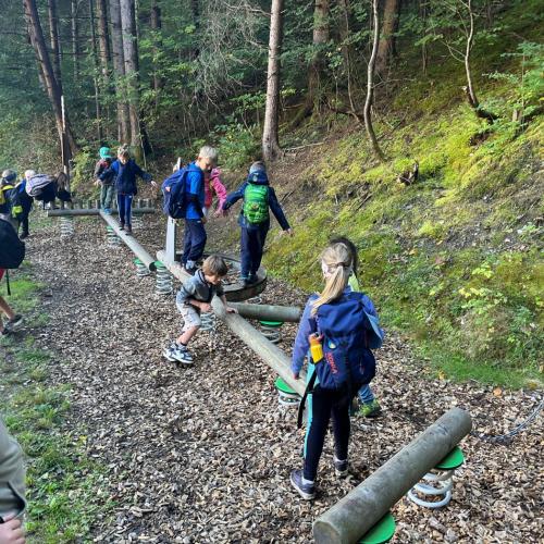Kinder beim Balancieren über Holzstämme